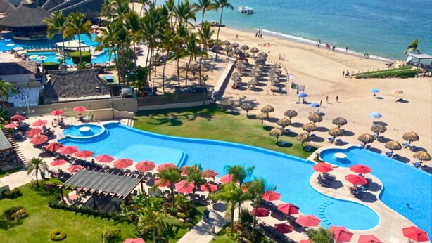 Un resort con una piscina grande, playa y vistas al océano.