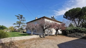 Une maison de plain-pied avec un toit en pente, une cheminée bien visible et un petit porche.