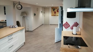 Une cuisine moderne avec un plan de travail en bois, une cuisinière encastrée et une horloge murale.