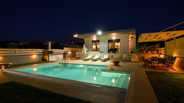 A modern outdoor pool area with a pool, lounge chairs, and a bar area. - Smaris Collection luxury villas.Sea side villa 5 min.from the beach ! (Σίσι)
