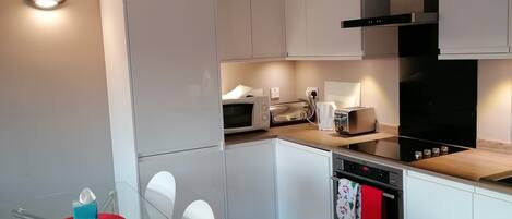 Apartment, 1 King Bed | Private kitchen | Fridge, stovetop, dishwasher, electric kettle