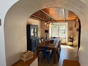 Een keuken met een houten tafel, blauwe stoelen en een kast.