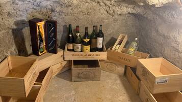Des caisses en bois contenant des bouteilles de vin, et une boîte portant l’inscription « Domaine de Chevalier », le tout placé devant un mur à texture.