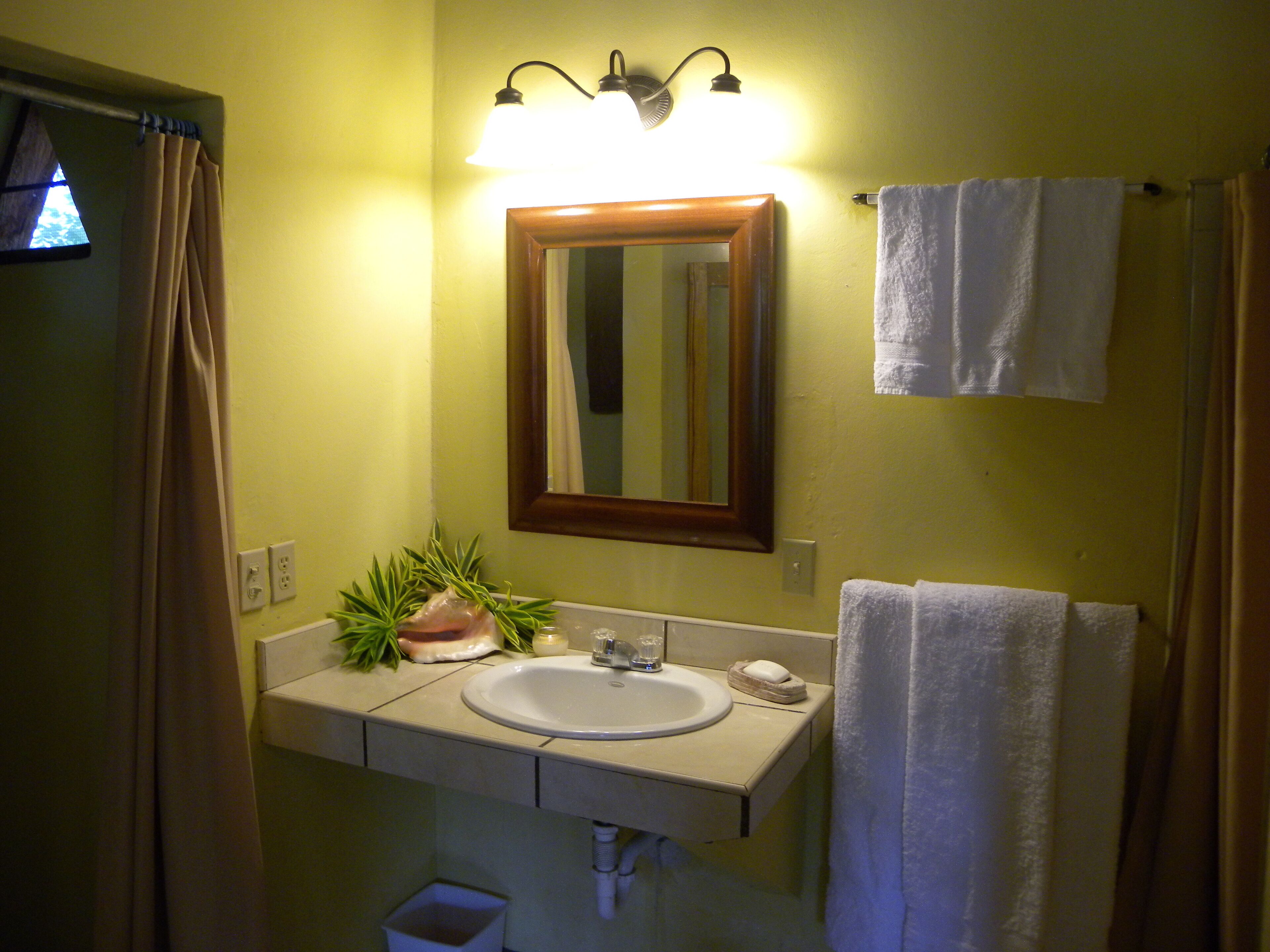 A bathroom with a sink, mirror, and towel rack.