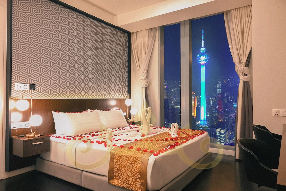 A hotel room with a large bed, a city view, and a modern design.