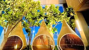 A night view of a building with three hanging wicker chairs under a tree. - Tropicana The Residence KLCC Golden Crown (Kuala Lumpur)