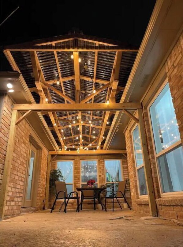 Enjoy dining or socializing under the pergola, surrounded by brick walls and comfortable seating.