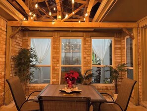 Cozy dining area with a wooden table for two, brick wall, and exposed beams.