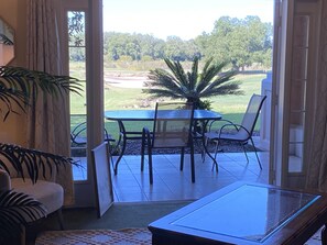 Relax in this serene room with a patio, featuring a glass table and comfortable seating for four.