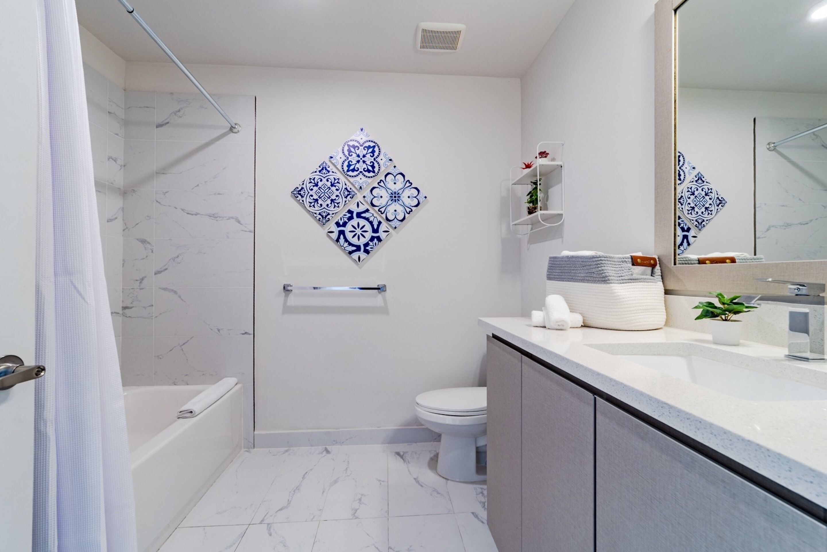 A modern bathroom with a shower, toilet, and sink.
