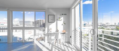 Una habitación amplia con ventanas grandes, un escritorio y vistas a la ciudad.