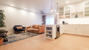 A modern kitchen with white cabinets, a built-in oven, and a coffee maker. - Centrally Located (Eugene)
