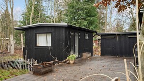 A cabin with a wooden deck, a small window, and a door. - Gorgeous home in Strøby with kitchen (Strøby)