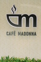 Logotipo com as letras 'm' e 'm' entrelaçadas, acima do texto 'CAFÉ MADONNA'.