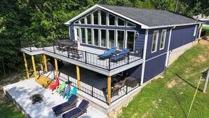 A two-story house with a balcony, outdoor seating area, and a deck. - Incredible KY Lake Waterfront Home with Dock (Gilbertsville)