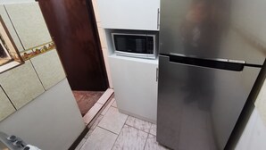 A compact kitchen with a stainless steel refrigerator, a microwave, and a small cabinet. - Beautiful apartment in the city center (Arequipa)