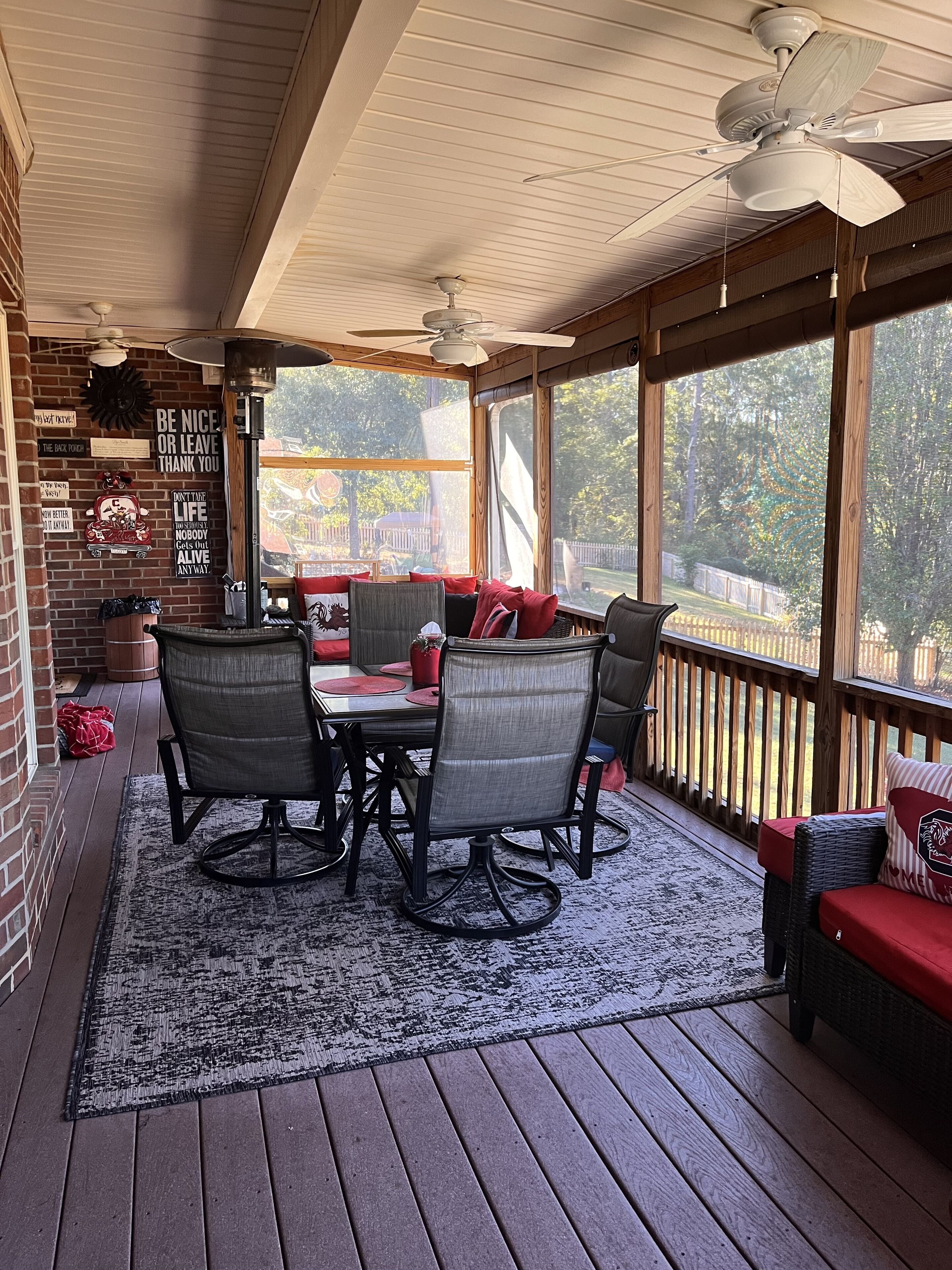 A covered patio with a table and chairs, a ceiling fan, and a view of the outdoors.