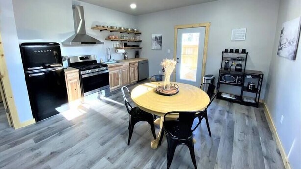 A modern kitchen with a central island, built-in oven, and stainless steel appliances. - Couples Getaway & Business Travel- 6 Miles to MTU (Chassell)