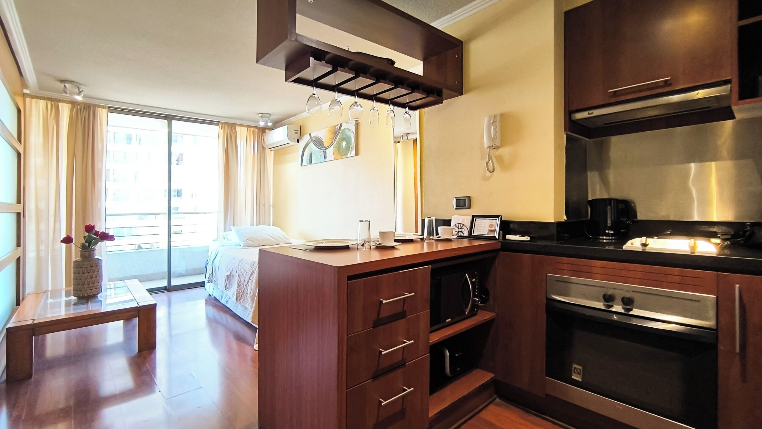A modern kitchen with wooden cabinets, a built-in oven, and a coffee maker.