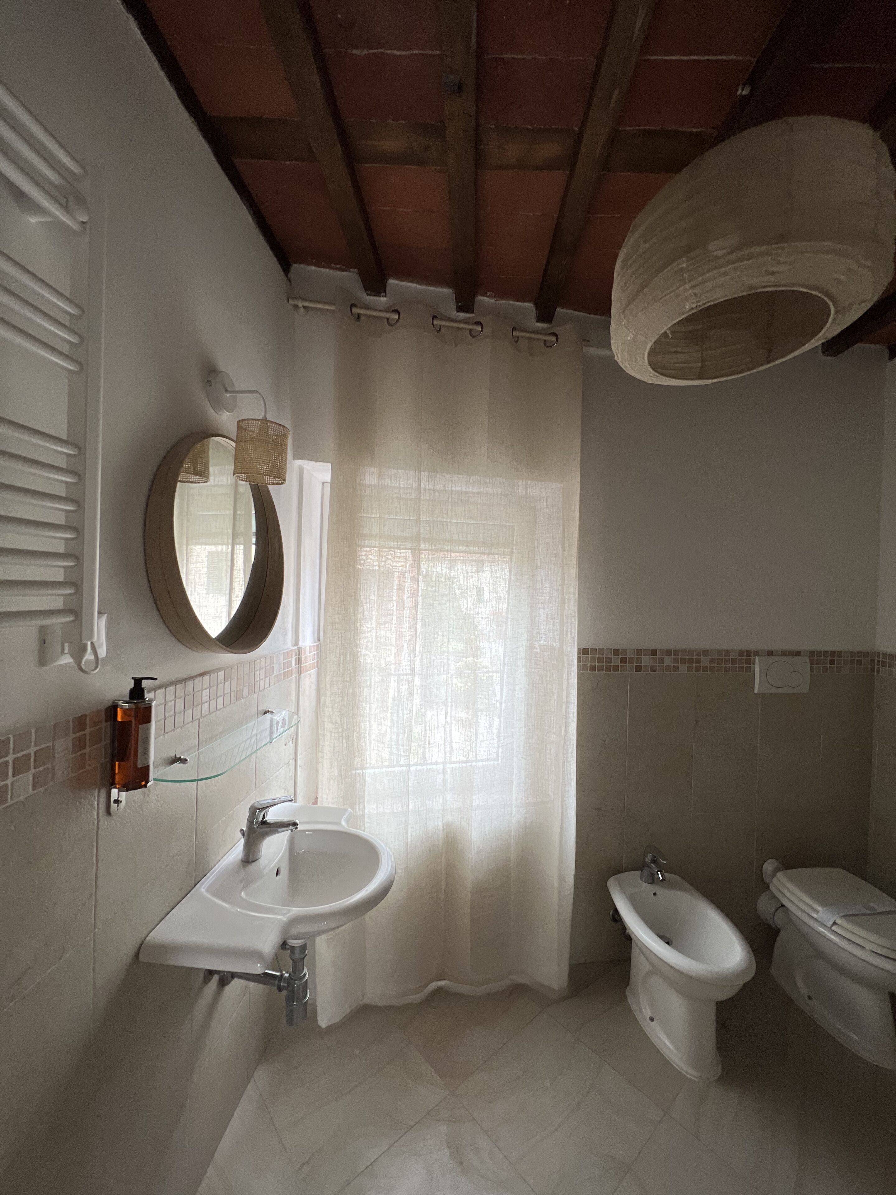 A bathroom with a sink, mirror, and two toilets.