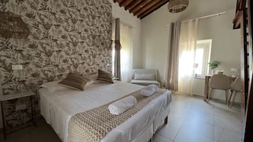 Un dormitorio con una cama grande, techo de madera y papel tapiz floral.