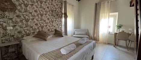 A bedroom with a large bed, a wooden ceiling, and a floral wallpaper.