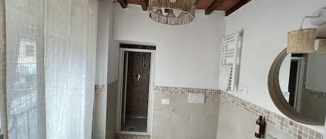 A bathroom with a shower, toilet, and two sinks.