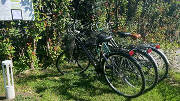 A bicycle parked in a grassy area with a sign in the background.
