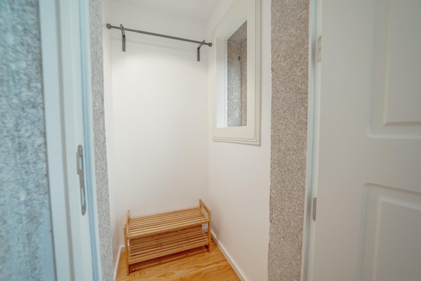 A narrow hallway with a wooden bench, a towel rack, and a small window. - Downtown Premium Apartment by Vacationy (Porto)