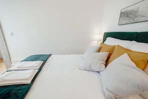 A neatly made bed with white and green bedding, a green headboard, and a white pillow. - Downtown Premium Apartment by Vacationy (Porto)