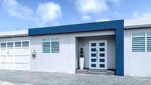 A modern building with a garage door, a mailbox, and a door with a small garden. - Modern Chic home close to airport and beach (Carolina)