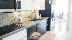 A modern kitchen with a black refrigerator, stainless steel appliances, and a tiled backsplash. - Modern Chic home close to airport and beach (Carolina)