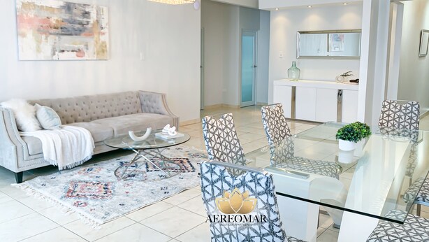 A modern living room with a sofa, coffee table, patterned chairs, and a glass dining table. - Modern Chic home close to airport and beach (Carolina)