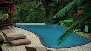 A swimming pool with lounge chairs and a lifebuoy. - Bali Jungle Camping (Pupuan)
