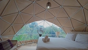 A dome-shaped tent with a bed, a chair, and a fan. - Bali Jungle Camping (Pupuan)