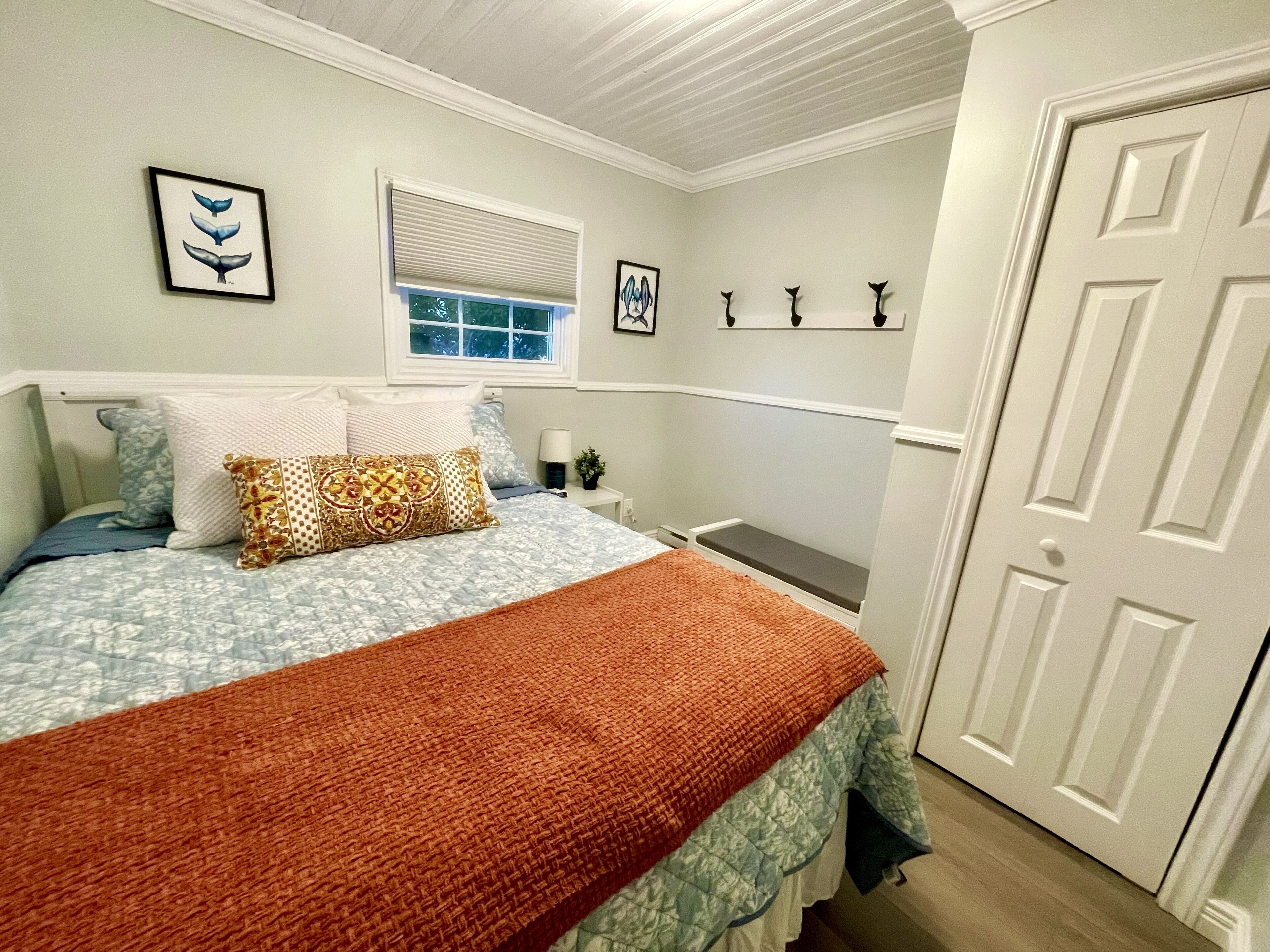 Une chambre à coucher avec un lit, une fenêtre, une porte et des éléments décoratifs sur les murs.