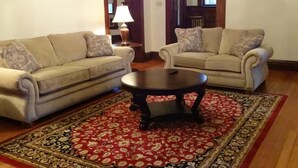 Un salon avec deux canapés, une table basse et un tapis à motifs.