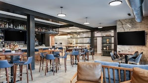 A modern bar area with multiple seating options, including bar stools and cushioned chairs, and a television mounted on the wall. - Hyatt Place Newark - Main Street (Newark)