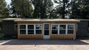 Un petit bâtiment d’un seul étage, avec une façade en bois et de grandes fenêtres.