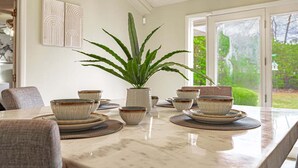 A dining area with a marble table, ceramic bowls, and a potted plant. - Waterfront Paradise with Golf Course Views (Florence)