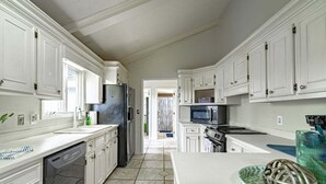A modern kitchen with white cabinetry, a dishwasher, a refrigerator, a microwave, and an oven. - Waterfront Paradise with Golf Course Views (Florence)