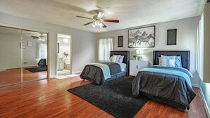 A bedroom with two beds, a ceiling fan, and a large mirror. - Waterfront Paradise with Golf Course Views (Florence)