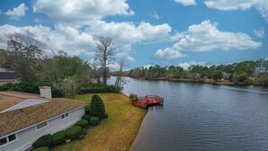 A riverside property with a house, a dock, and a grassy area. - Waterfront Paradise with Golf Course Views (Florence)