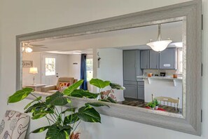 A living room with a large mirror reflecting a kitchen and dining area. - The Perch @ Bryant's Roost (Bell Buckle)