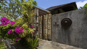A stone wall with a metal door and a sign labeled "G". - Moritz Palm Villa (Kutuh)