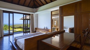A bedroom with a large bed, wooden furniture, and a view of the ocean. - Moritz Palm Villa (Kutuh)
