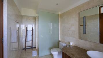 Un baño con inodoro, lavabo y zona de ducha.