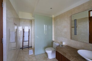 Un baño con inodoro, lavabo y zona de ducha.