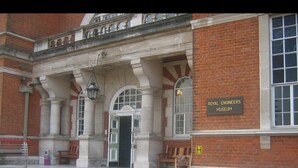 Der Eingang zum Royal Engineers Museum mit einem Schild, Stufen, die zum Eingang führen, und Bänken davor.