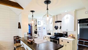 A kitchen with a central island, white cabinetry, and pendant lighting. - Charming Three Bdrm Home on Quiet Street- Near U of M - Fully Fenced Yard- (Memphis)